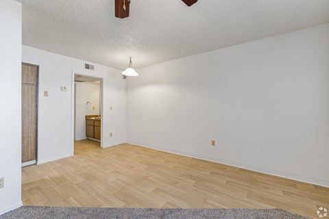 a living room with a hard wood floor and white walls